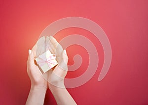 A small gift with a pink bow in women`s hands photo