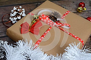 Small gifts packed in craft paper and various Christmas decorations on wooden background