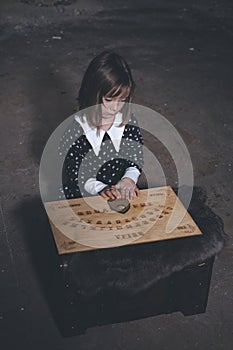 Small girl alone in old house in style of halloweeen witch