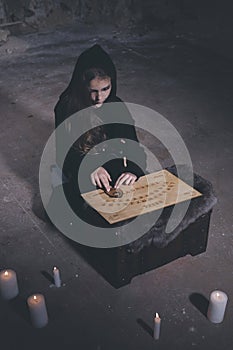 Small girl alone in old house in style of halloweeen witch