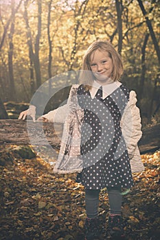 Small girl alone in wild forest in style of halloweeen witch