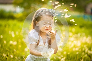 Small girl blowing dandelion