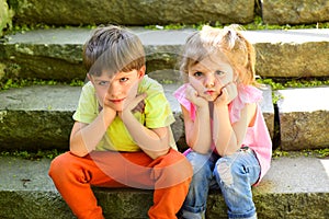 Small girl and boy on stairs. Relations. summer vacation. childhood first love. couple of little children. sad boy and