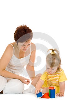 Small girl build pyramid with mother