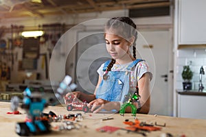 Small girl making a robot
