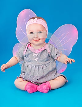 Small girl butterfly wings sitting on the floor