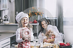 Small girl child eats a donut with my mom and sister happy cook