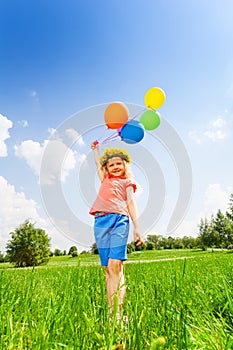 Small girl with colorful balloons wearing circlet