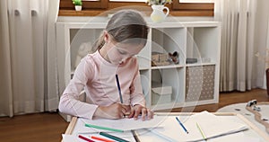 Small girl enjoy drawing using crayons at cozy child room