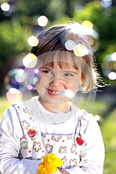 Small girl with a flower and soap bubbles photo