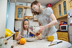 Small girl going to beat the dough for pancakes