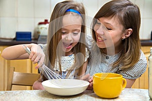 Small girl going to beat the dough for pancakes