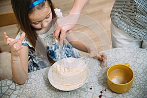 Small girl going to beat the dough for pancakes