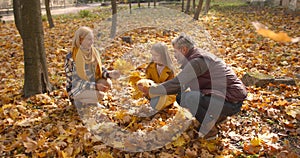 Small girl with grandparents on a walk in autumn forest