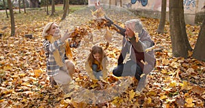 Small girl with grandparents on a walk in autumn forest