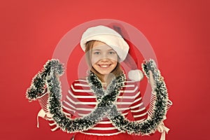 Small girl having fun. funny little id play with tinsel. santa kid with tinsel decor. xmas holiday decoration. time for