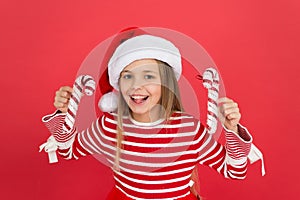 Small girl having fun. santa elf kid candy cane decor. xmas holiday decoration. christmas shopping time. happy new year