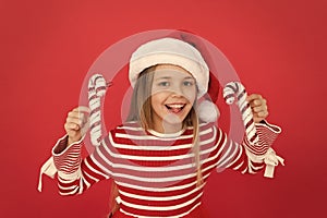 Small girl having fun. santa elf kid candy cane decor. xmas holiday decoration. christmas shopping time. happy new year