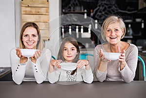 A small girl with mother and grandmother at home.