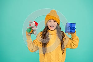 Small girl hold mouse toy and present box. child knitted clothes play with toy rat. toy shop for kids. christmas is here