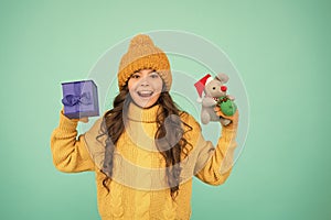 small girl hold mouse toy and present box. child knitted clothes play with toy rat. toy shop for kids. christmas is here