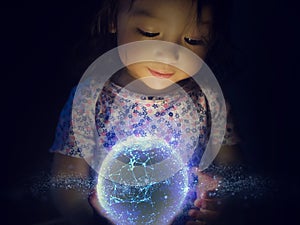 Small Girl Holds Glowing Orb of Modern Technology