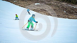Small girl learning to ski with ski poles