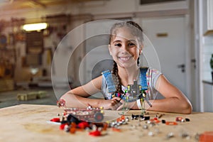 Small girl making a robot