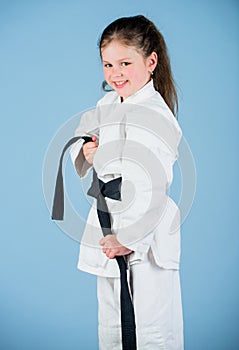 Small girl in martial arts uniform. little girl in gi sportswear. practicing Kung Fu. happy childhood. knockout. energy