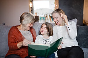 A small girl with mother and grandmother at home.