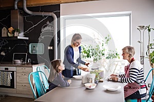 A small girl with mother and grandmother at home.