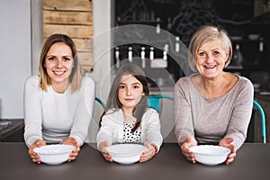 A small girl with mother and grandmother at home.