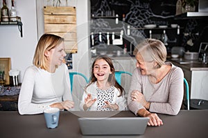 A small girl with mother and grandmother at home.