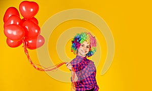 Small girl in periwig. valentines day party. child wear rainbow wig hair yellow background. happy kid hold party