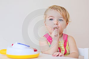 Small girl playing indoors eating candy