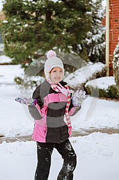 Small girl playing with snow on sunny day.