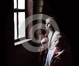 Small girl praying at the window