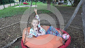 Small Girl Is Riding On A Swing