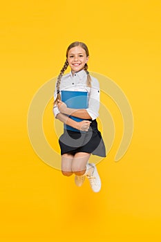 Small girl in school uniform. cheerful girl with workbook. Education. dictionary notebook. Get information. reading