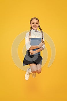 Small girl in school uniform. cheerful girl with workbook. Education. dictionary notebook. Get information. reading