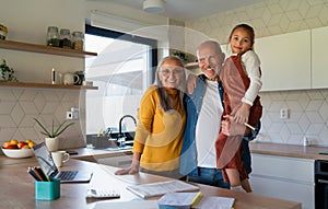 Small girl with senior grandparents doing maths homework at home.