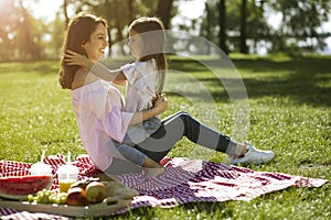 Small girl sitting on mother laps in the park small girl sitting on mother laps in the park