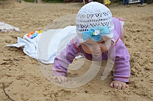 Small girl sitting on sand at beach