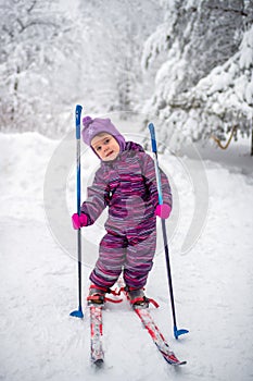 A small girl is skiing on the snow