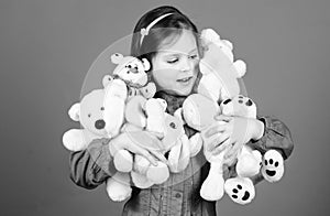 Small girl smiling face with toys. Happy childhood. Little girl play with soft toy teddy bear. Lot of toys in her hands