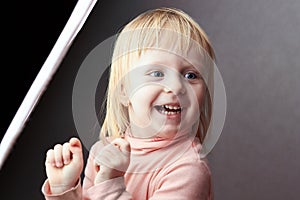 Small girl stands beside a softbox photo