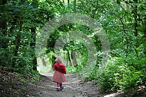 Small girl walking through the forest