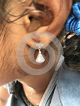 Small girl wearing silver made ear ring ornament
