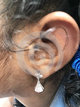 Small girl wearing silver made ear ring ornament