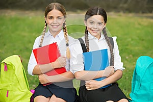 Small girls with books and backpacks. children hold notebook for making notes. happy childhood. back to school. teen